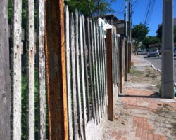 Cerca com alguns trilhos fincados na calçada